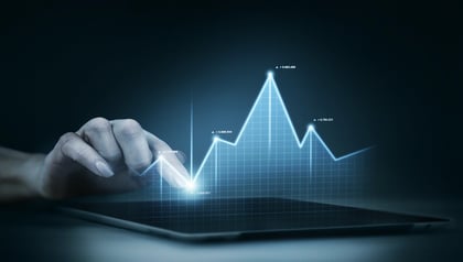 Hand interacting with a glowing holographic stock market growth graph, representing emerging application modernization trends