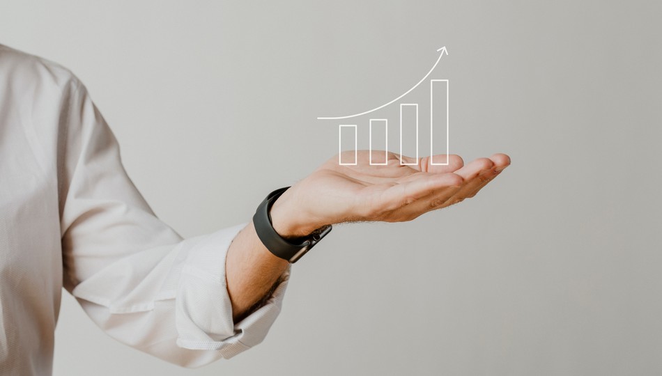 Businessman holding out an open palm with a rising bar graph illustration above it, representing the growth benefits of application modernization