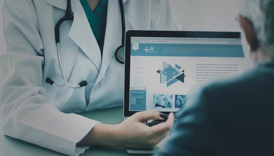 Custom software development for healthcare organizations shown by a doctor reviewing a hospital platform on a laptop.