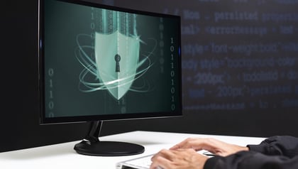 GDPR data protection outsourcing shown through a shield icon and binary code on a computer screen.