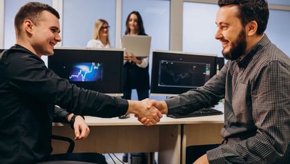 How to choose an MVP development partner shown through two professionals shaking hands in an office.