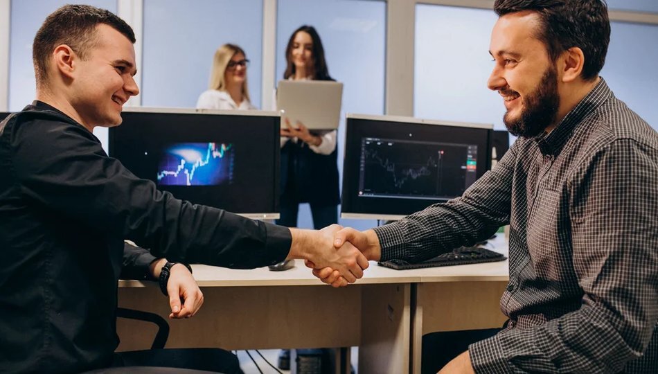 How to choose an MVP development partner shown through two professionals shaking hands in an office.