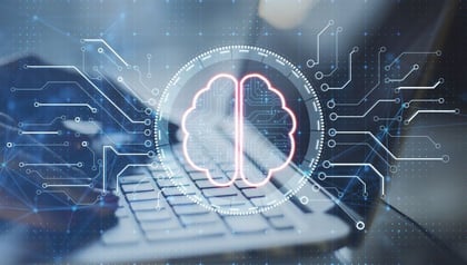 Top 10 machine learning development companies shown by hands typing on a laptop with a digital brain graphic.