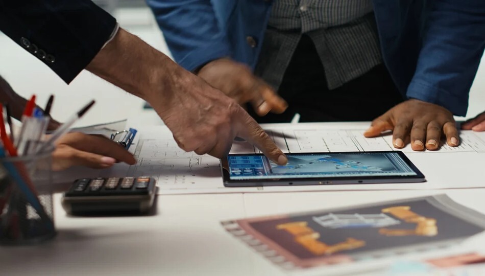 Top platform modernization companies for enterprises shown by a team reviewing plans on a tablet.