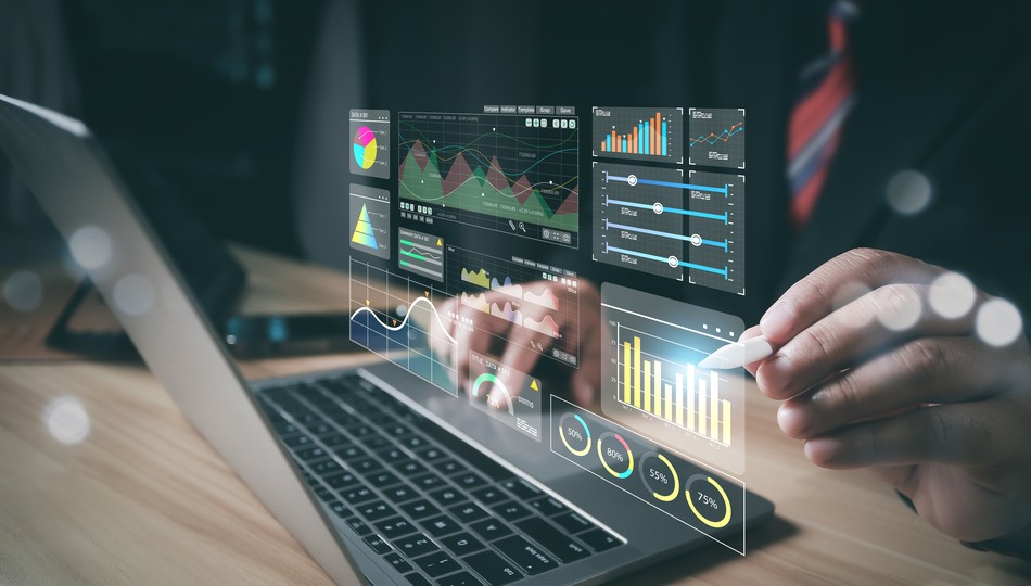 Hand using a stylus over a laptop displaying holographic data dashboards with charts, graphs, and KPI percentages, representing data strategy