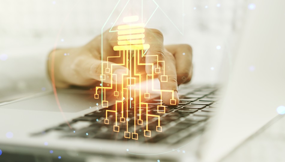 Glowing lightbulb and microcircuit graphic overlaid on hands typing on a laptop keyboard, symbolizing legacy application modernization